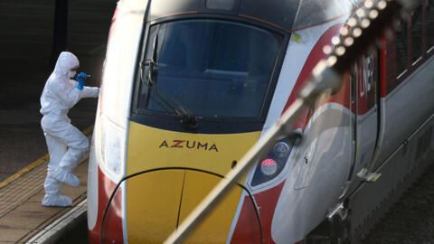 يقوم ضابط الطب الشرعي بفحص قطار شركة السكك الحديدية "لندن نورث إيسترن ريلواي" (LNER) حيث وقعت سلسلة من حوادث الطعن، وذلك على أحد أرصفة محطة هنتينغدون، بالقرب من كامبريدج، بريطانيا، في 2 نوفمبر 2025.