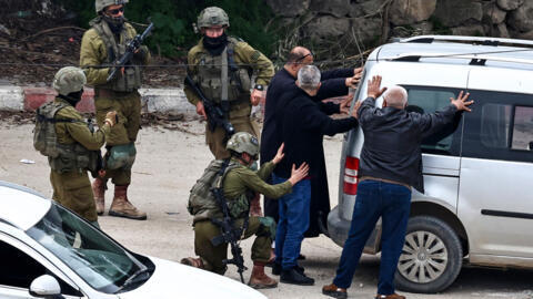 قوات الجيش الإسرائيلي تعتقل عدداً من الشبان الفلسطينيين بعد تفتيشهم خلال مداهمة نفذتها في مخيم طولكرم للاجئين الفلسطينيين في الضفة الغربية المحتلة، في 19 شباط/فبراير 2025.