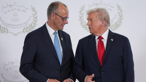 الرئيس الأمريكي دونالد ترامب يحيي المستشار الألماني فريدرش ميرتس خلال قمة شرم الشيخ للسلام، بتاريخ 13 أكتوبر/تشرين الأول 2025.