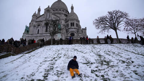 رجل يلعب في حي مونمارتر المغطى بالثلوج بباريس، يوم الأربعاء 7 يناير/كانون الثاني 2026.