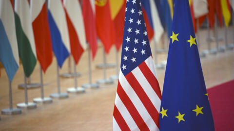 تم عرض علم الاتحاد الأوروبي (يمين) وعلم الولايات المتحدة في نهاية اجتماع مجلس الشؤون الخارجية للاتحاد الأوروبي حول التجارة في بروكسل في 24 نوفمبر 2025.