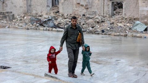 طفلان مع والدهما في غزة